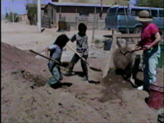 Kids shoveling sand.